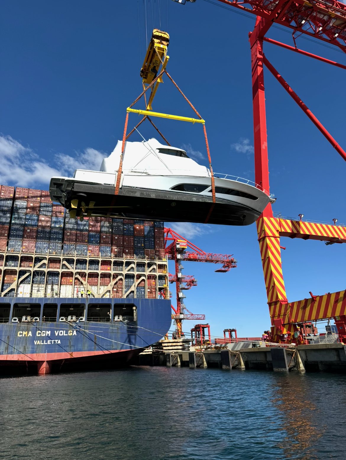 Wrapped launch lifted by crane onto a container ship