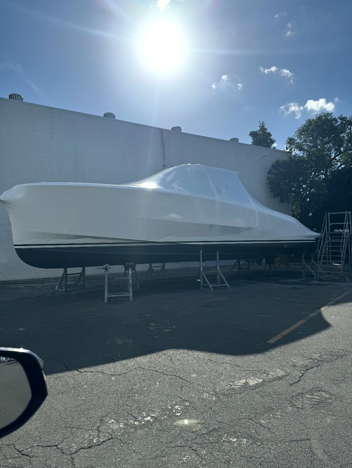 Wrapped sports-fisher on stands in a boatyard